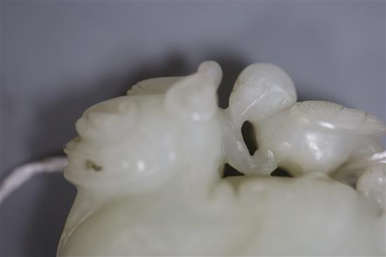 A Chinese white jade figure of bixi with a bird on its back, 17th/18th century, L. 5.4cm, wood stand